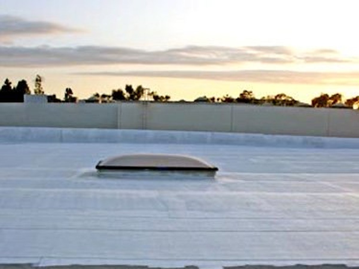 Flat commercial roof finished with a seamless white reflective coating